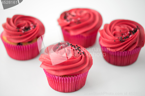 Image of close up of cupcakes with red buttercream frosting