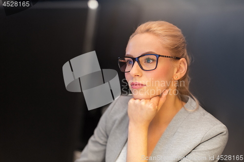 Image of businesswoman working at computer in night office