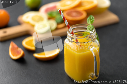 Image of mason jar glass of fruit juice on slate table top