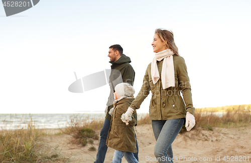 Image of happy family walking along autumn beach