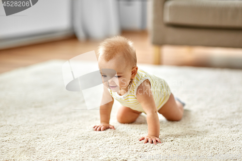 Image of lovely baby girl crawling on floor at home