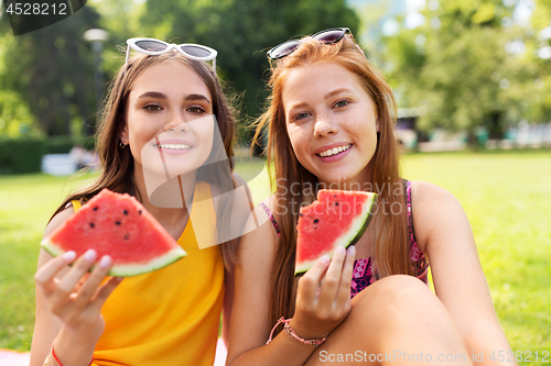 Image of teenage girls eating watermelon at picnic in park