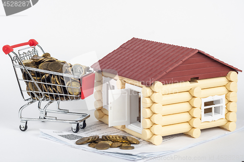 Image of Trolley with money on the bills for the apartment, next to the toy house