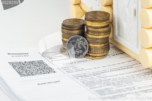 Image of A stack of money and one ruble coin in the bills for an apartment