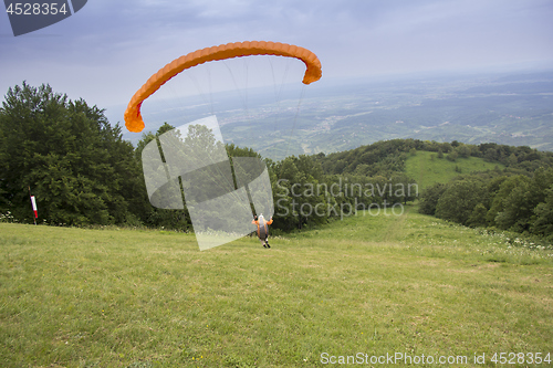 Image of Paraglider taking off from the edge of the mountain