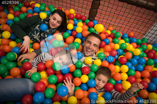 Image of young parents with kids in a children\'s playroom