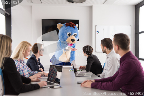 Image of boss dresed as bear having fun with business people in trendy of