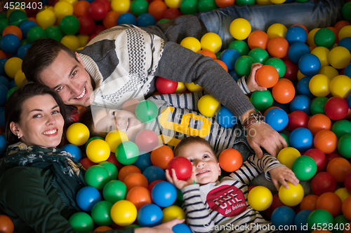 Image of young parents with kids in a children\'s playroom