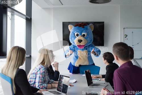 Image of boss dresed as bear having fun with business people in trendy of