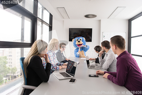 Image of boss dresed as bear having fun with business people in trendy of