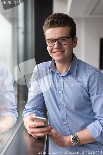 Image of Businessman Standing In A Modern Building Near The Window With P