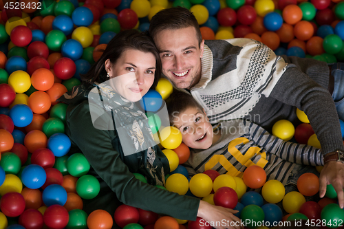 Image of young parents with kids in a children\'s playroom