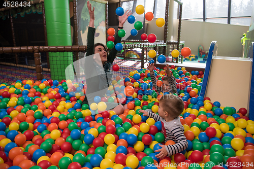 Image of Young mom with her kids in a children\'s playroom