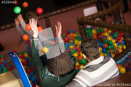 Image of young parents with kids in a children\'s playroom