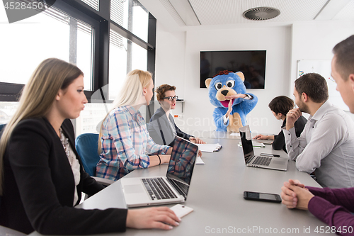 Image of boss dresed as bear having fun with business people in trendy of