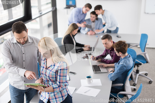 Image of Two Business People Working With Tablet in office