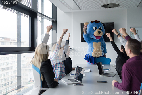 Image of boss dresed as bear having fun with business people in trendy of