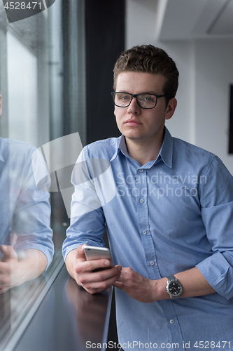 Image of Businessman Standing In A Modern Building Near The Window With P