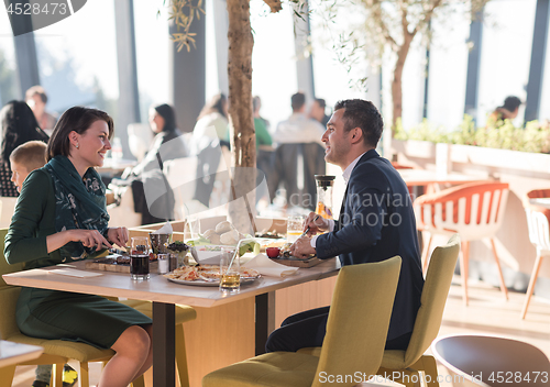 Image of Young parents enjoying lunch time with their children