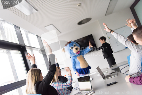 Image of boss dresed as bear having fun with business people in trendy of