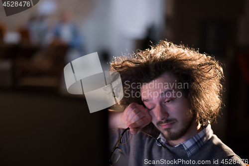 Image of man working on computer in dark office