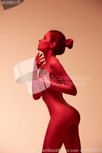 Image of fashion art photo of elegant nude model in the light colored spotlights