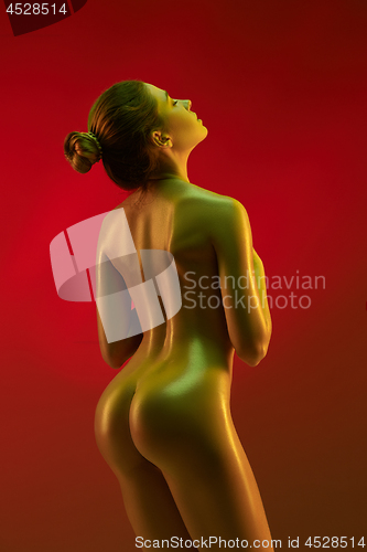 Image of fashion art photo of elegant nude model in the light colored spotlights