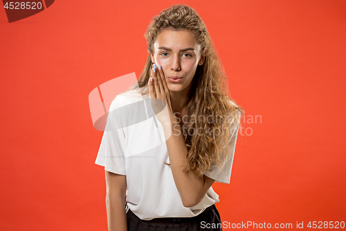 Image of The young woman whispering a secret behind her hand