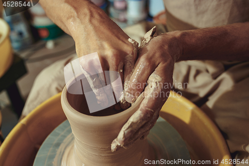 Image of Creating a jar or vase of white clay close-up. Master crock.