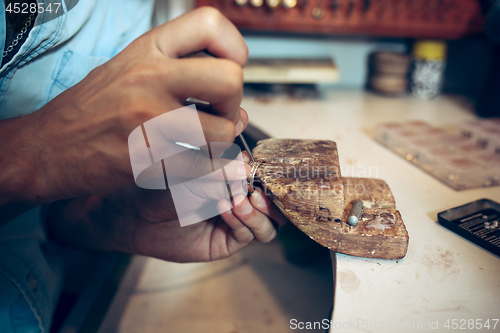 Image of Different goldsmiths tools on the jewelry workplace. Jeweler at work in jewelry.