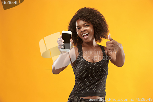 Image of Portrait of a confident casual afro girl showing blank screen mobile phone