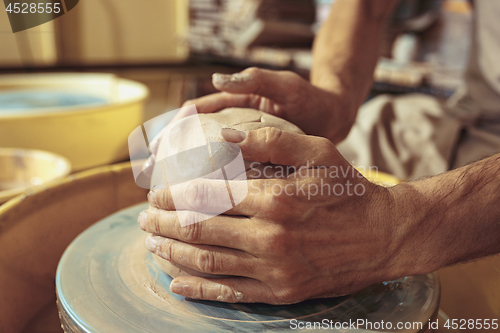 Image of Creating a jar or vase of white clay close-up. Master crock.