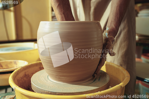 Image of Creating a jar or vase of white clay close-up. Master crock.