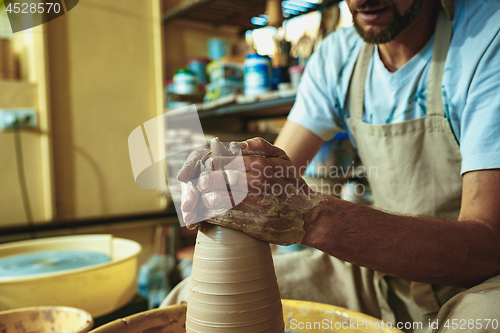 Image of Creating a jar or vase of white clay close-up. Master crock.