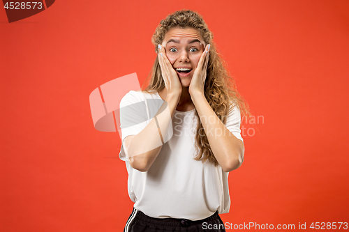 Image of Beautiful woman looking suprised isolated on orange