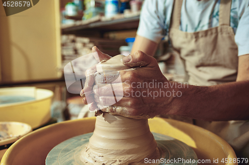 Image of Creating a jar or vase of white clay close-up. Master crock.