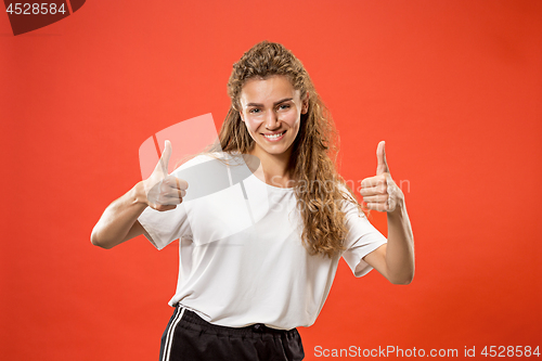 Image of The happy business woman standing and smiling against red background.