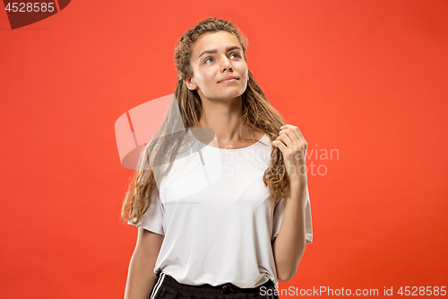 Image of The happy woman standing and smiling against red background.