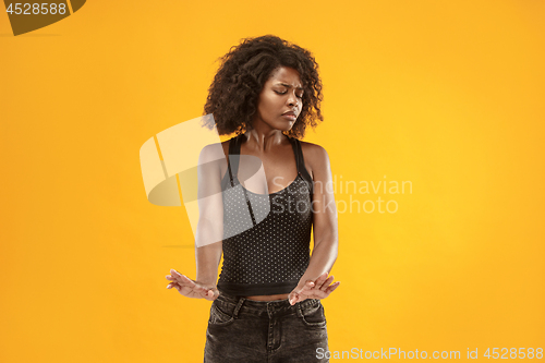 Image of Let me think. Doubtful pensive woman with thoughtful expression making choice against yellow background