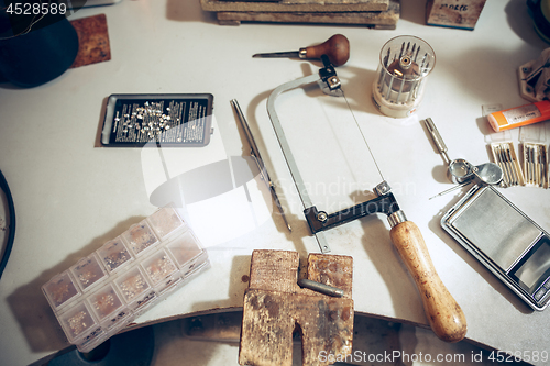 Image of Different goldsmiths tools on the jewelry workplace. work in jewelry.