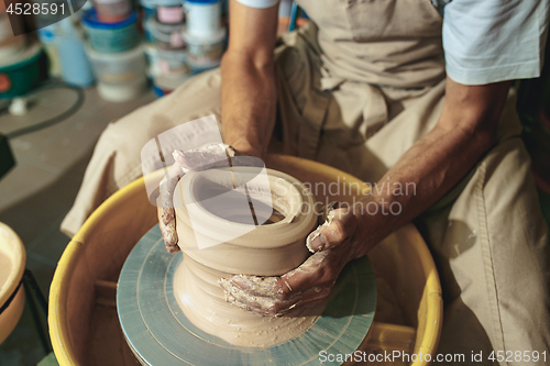 Image of Creating a jar or vase of white clay close-up. Master crock.