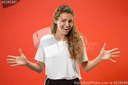 Image of Beautiful woman looking suprised isolated on orange