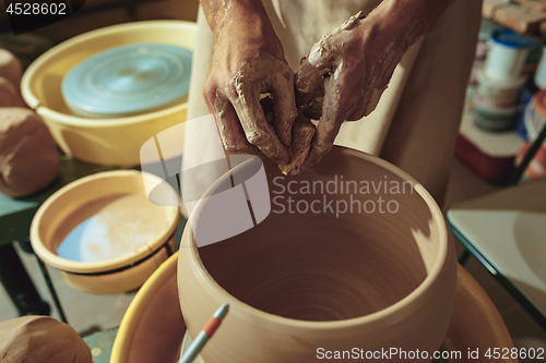 Image of Creating a jar or vase of white clay close-up. Master crock.