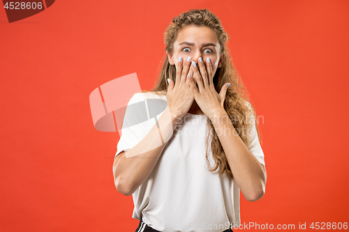 Image of Beautiful woman looking suprised isolated on orange