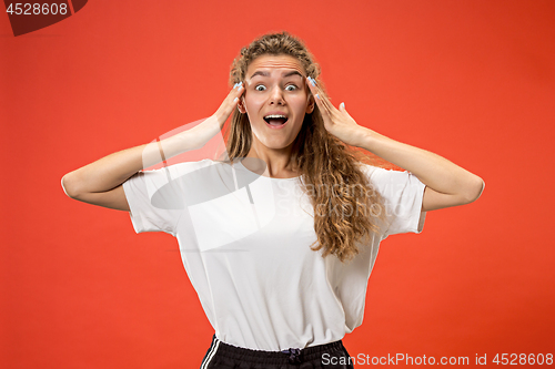 Image of Beautiful woman looking suprised isolated on orange