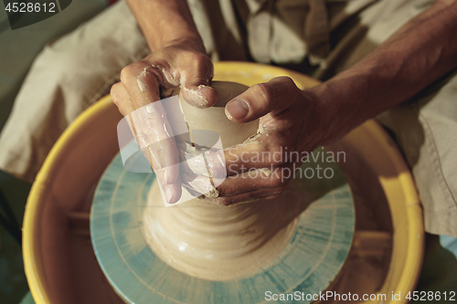 Image of Creating a jar or vase of white clay close-up. Master crock.