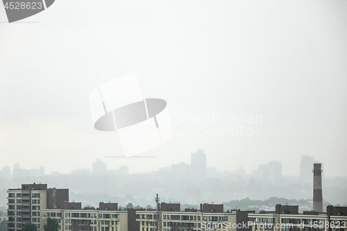 Image of A view of the new houses against the background of the silhouettes of buildings in the misty sky.