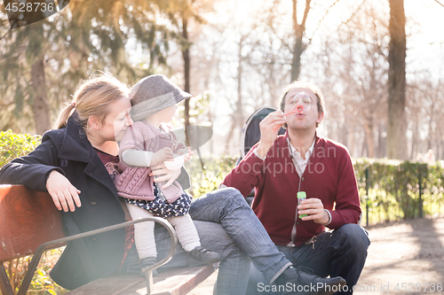 Image of Young family with cheerful child in the park.