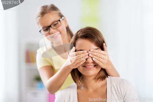 Image of happy mother and daughter playing guess who game