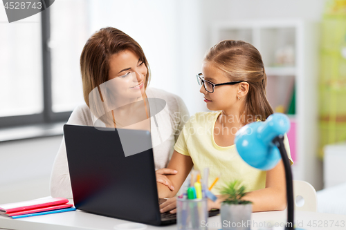 Image of mother and daughter with laptop doing homework